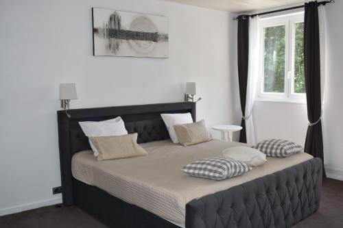 a bedroom with a large bed with pillows on it at Logis Manoir de Fourcy in Corbehem