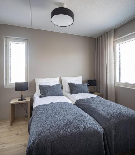a bedroom with a large bed and two windows at Levin Kunkku B1 in Levi