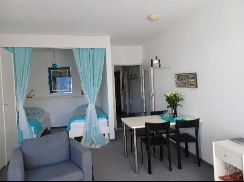 ein Wohnzimmer mit einem Tisch und Stühlen sowie ein Schlafzimmer in der Unterkunft Sollevante Ascona in Ascona