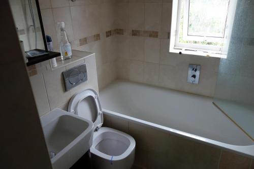 a bathroom with a toilet and a tub and a sink at NEW Cosy 2 Bedroom Flat - Englefield Green in Englefield Green