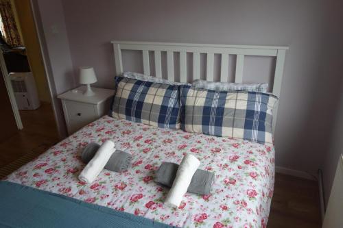 a bed with two pillows and two candles on it at NEW Cosy 2 Bedroom Flat - Englefield Green in Englefield Green