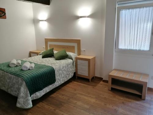 a bedroom with a bed with green sheets and pillows at Casa Xestadelo in Aldán