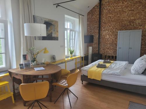 una camera con letto, tavolo e sedie di Mille Fleurs - apartments a Voeren