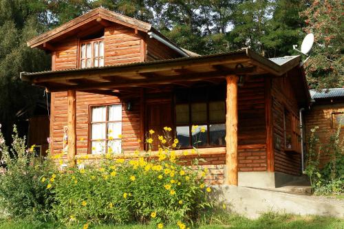 a log cabin with a window on the side of it at Cabañas del Faldeo Titos in El Bolsón