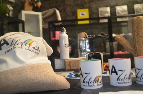 a hat and three coffee cups on a table at HOTELITO RURAL GA7COLORES only adult in Montaña Blanca