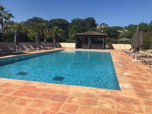 a swimming pool with chairs and a gazebo at Charmantes Haus im Golf Club Saint Tropez in Saint-Tropez