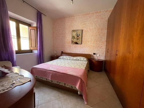 um pequeno quarto com uma cama e uma janela em La casa di Dedda I.U.N. Q4233 em Santa Caterina