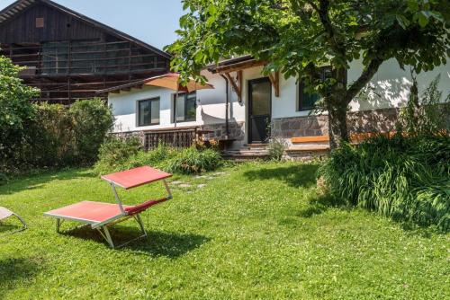 a table and a chair in front of a house at AppartChalet LA RONDULA - 100m from Seceda in Ortisei