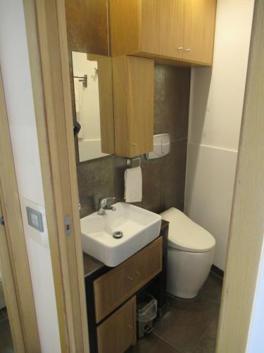 a small bathroom with a sink and a toilet at Alba Chiara in Acitrezza