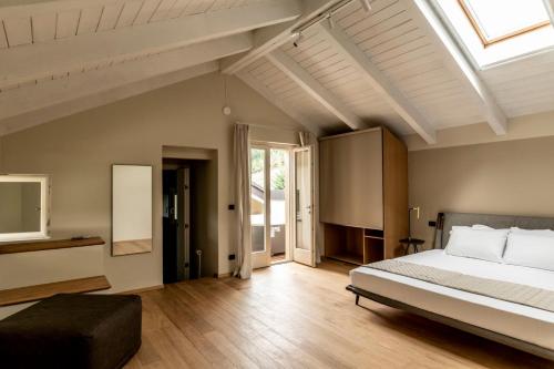 sypialnia z dużym łóżkiem i oknem dachowym w obiekcie Parco Reala // Rural - Luxury - Rooms w mieście Corneliano d'Alba