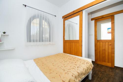a bedroom with a bed and a wooden door at Apartments Danica in Murter