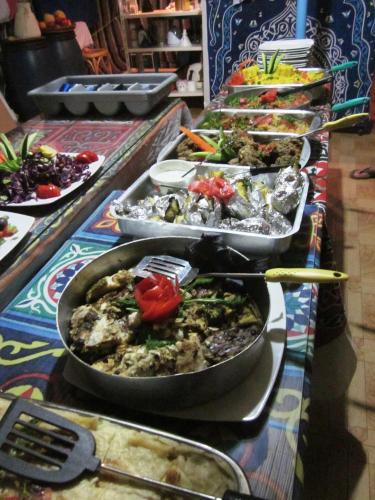 a buffet line with many pans of food on a table at Bet El Kerem Guesthouse in Aswan