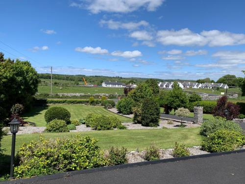 a view of a garden with trees and bushes at Kilcarragh House in Kilfenora