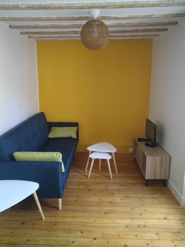 un salon avec un canapé bleu et une table dans l'établissement Suzon appartement idéalement situé, à Bayeux