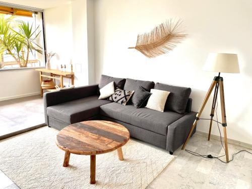 uma sala de estar com um sofá e uma mesa de centro em Plage Landsberg Appartement 2 pièces en bord de mer em Saint-Laurent-du-Var