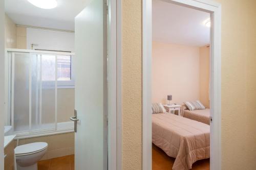 a bathroom with a bed and a toilet in a room at Finca La Capella in Poblet