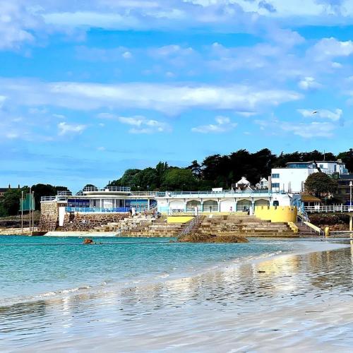 a view of the beach with buildings in the background at De L'Etang in Saint Helier Jersey