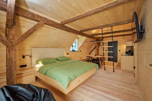 a bedroom in a log cabin with a bed at NATUR BAJTA in Solčava