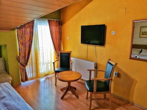 a living room with a table and chairs and a tv at ***Vila To&scaron;e D. Kru&scaron;evo in Kru&scaron;evo