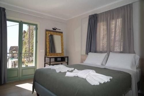een slaapkamer met een bed met handdoeken erop bij Saint george Hotel Parga in Parga