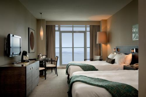 a hotel room with two beds and a desk at The Sidney Pier Hotel & Spa in Sidney