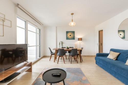 un salon avec un canapé bleu et une table dans l'établissement Family Garden by Plaza - Proche Disneyland Paris, à Chessy