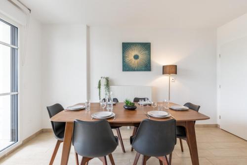 une salle à manger avec une table et des chaises en bois dans l'établissement Family Garden by Plaza - Proche Disneyland Paris, à Chessy
