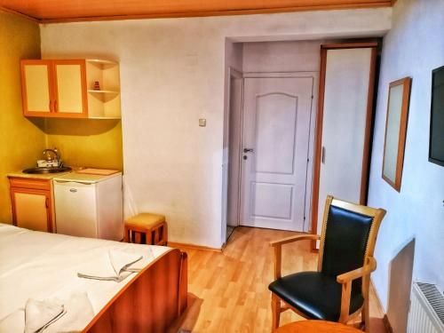a room with a bed and a chair and a kitchen at ***Vila Toše D. Kruševo in Kruševo