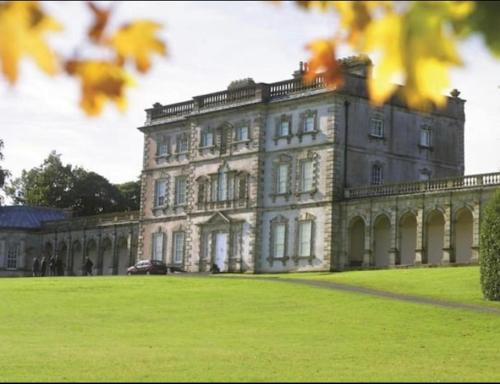 a large stone building on a field of grass at Corraglass House - close proximity to Cuilcagh in Letterbreen