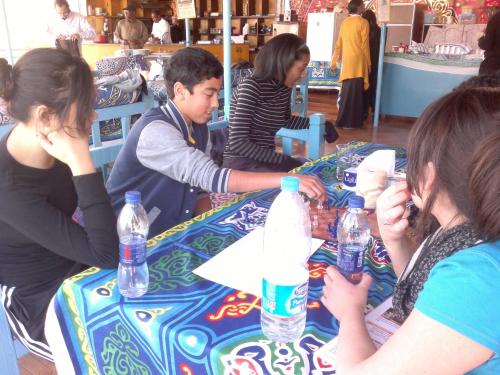 a group of people sitting around a table with water bottles at Bet El Kerem Guesthouse in Aswan