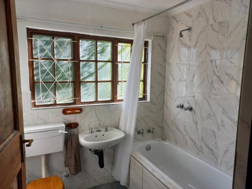 a bathroom with a sink and a bath tub and a sink at Marula Gardens in Mtubatuba