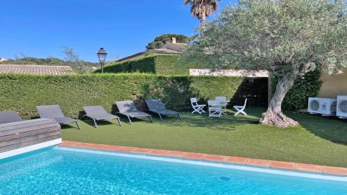 une piscine avec des chaises, une table et un arbre dans l'établissement Restanques - Beauchêne, à Sainte-Maxime