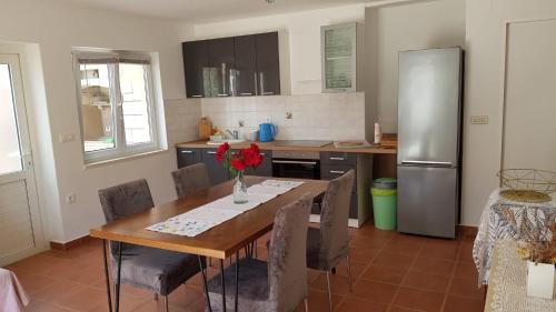 a kitchen with a wooden table and a refrigerator at Apartments Katarina in Sutivan