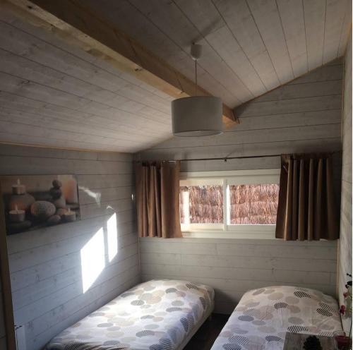 mały pokój z łóżkiem i oknem w obiekcie Adorable chalet des Huttiers - Bassin d'Arcachon w mieście Audenge