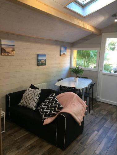 ein Wohnzimmer mit einem Sofa und einem Tisch in der Unterkunft Adorable chalet des Huttiers - Bassin d'Arcachon in Audenge
