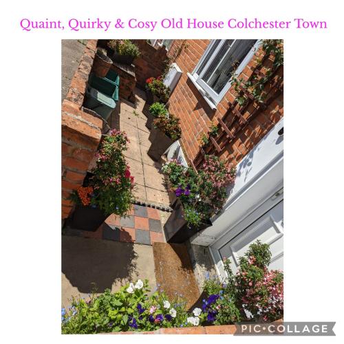 an old house with flowers on the side of a building at Quaint & Quirky House Colchester Town Centre in Colchester