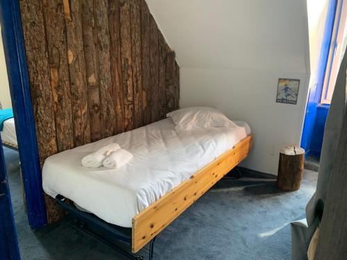a bed in a room with a wooden headboard at Le Pourquoi pas in La Bourboule