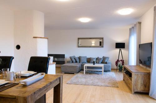 モントゼーにあるApartment Schafbergblick mit Balkonのソファとテレビのあるリビングルーム