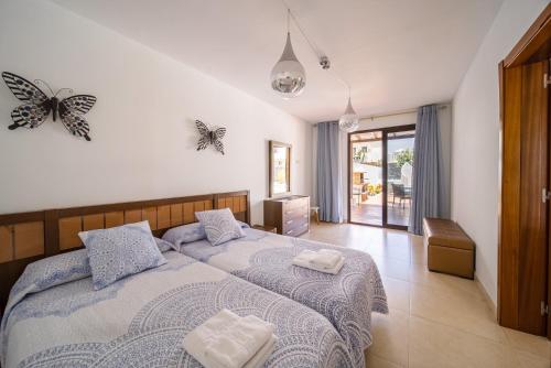 a bedroom with two beds and butterflies on the wall at Villa Turquesa in Playa Blanca