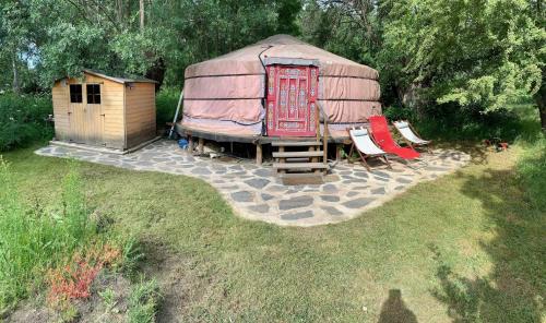 a yurt with two chairs and a house at La Yurta de Gaia in San Lorenzo de El Escorial