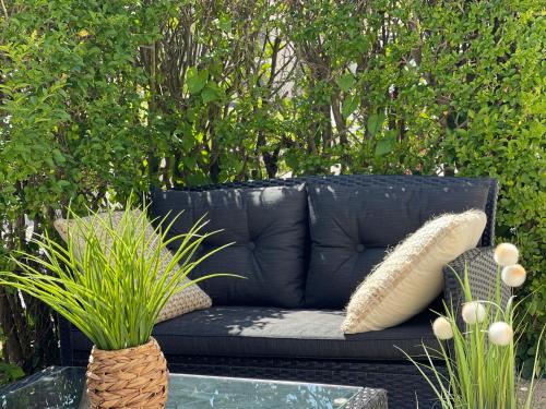 a black couch with pillows sitting on a patio at Les Mouettes in Escalles