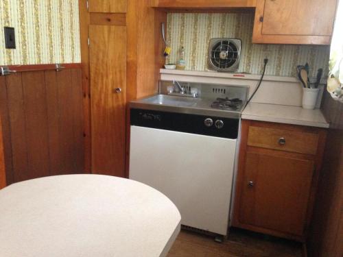 eine kleine Küche mit Herd und Spüle in der Unterkunft Amber Lantern Two-Bedroom Cottage in Lake George