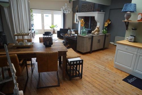 uma cozinha e sala de estar com uma mesa e um sofá em Bed and Breakfast Unique em Enschede