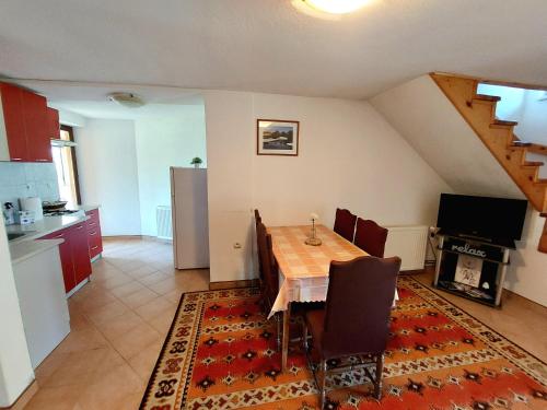 Apartments & rooms Velebit في Lovinac: مطبخ وغرفة طعام مع طاولة وكراسي