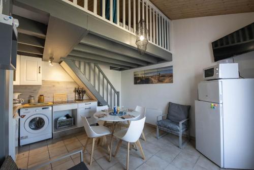 une cuisine et une salle à manger avec une table et un réfrigérateur dans l'établissement Maison pour 4 pers - Terrasse - 300m de la plage, à Noirmoutier-en-l'lle