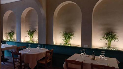 ein Restaurant mit Tischen und Stühlen mit Pflanzen an den Wänden in der Unterkunft Relais Borgo sul Mare Ospitalità diffusa in Silvi Paese