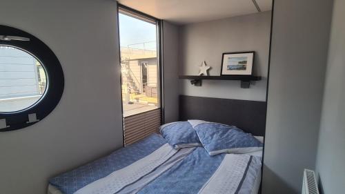a small bedroom with a bed and a mirror at Hausboot La Mare Sonja in Weyhe
