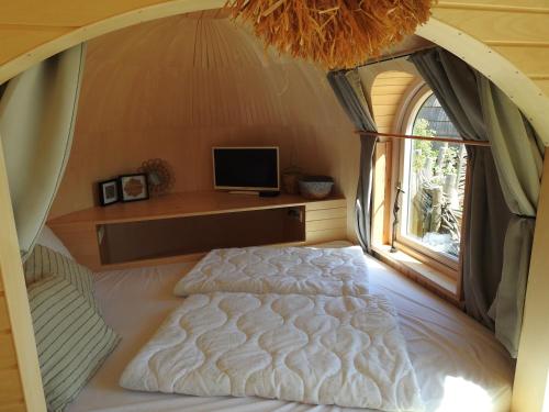 een slaapkamer met een bed en een raam bij De Hut, in Natuurgebied en vlakbij het Strand in Callantsoog