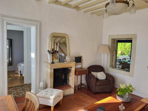 un salon avec une cheminée et un miroir dans l'établissement Les Lilas de Bellefontaine, à Bayeux