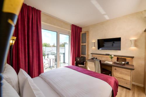 a hotel room with a bed and a desk and a television at R&R Hotel Störtebeker in Baabe